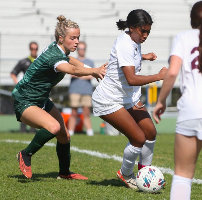 Saint Mark's Lily Phillips (left) moves against Caravel's Maci Hood in the first half of the Bucs' 1-0 overtime win at Saint Mark's High School, Wednesday, April 24, 2024.