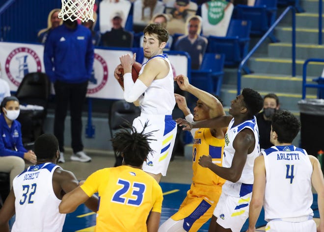 Delaware's Johnny McCoy (top) grabs a rebound in the first half of the Blue Hens' 74-56 win against Hofstra at the Bob Carpenter Center Friday, Jan. 15, 2021.
