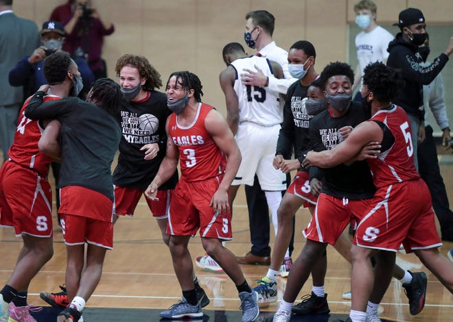 Smyrna players celebrate after the Eagles' 43-42 win in a semifinal of the DIAA state tournament at Salesianum Thursday, March 11, 2021.