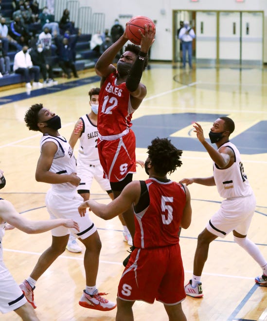 Smyrna's Olumuyiwa Salako (12) goes to the net in the final seconds before getting his own rebound and getting sent to the free throw line for the winning basket in the Eagles' 43-42 win in a semifinal of the DIAA state tournament at Salesianum Thursday, March 11, 2021.