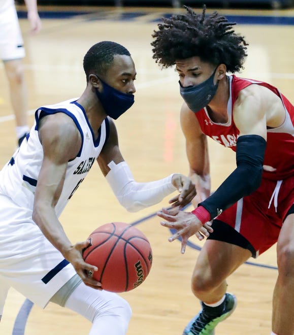Salesianum's Rasheen Caulk (left) drives against Smyrna's Elijah Credle in the Eagles' 43-42 win in a semifinal of the DIAA state tournament at Salesianum Thursday, March 11, 2021.