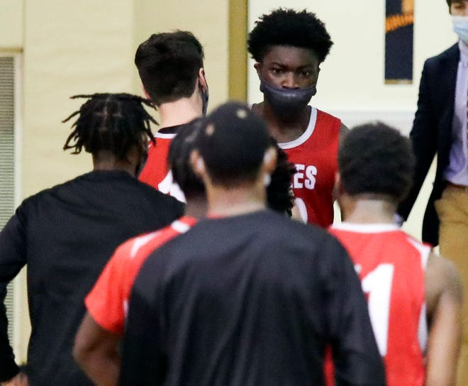 Smyrna's Olumuyiwa Salako is swarmed by his teammates after he hit a free throw in the final second to secure the Eagles' 43-42 win in a semifinal of the DIAA state tournament at Salesianum Thursday, March 11, 2021.