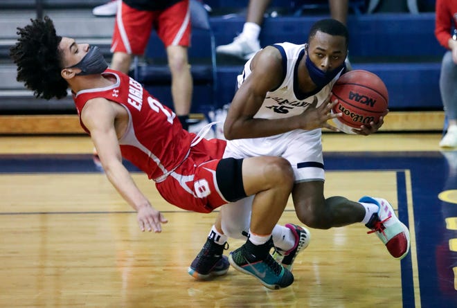 Smyrna's Elijah Credle (left) loses his footing after contact with Salesianum's Rasheen Caulk in the Eagles' 43-42 win in a semifinal of the DIAA state tournament at Salesianum Thursday, March 11, 2021.